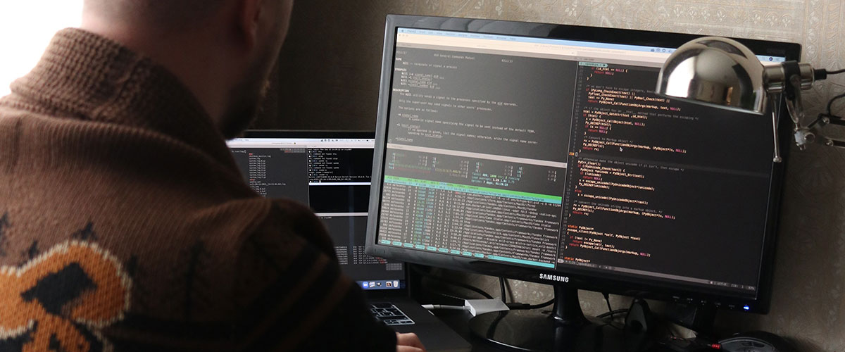 man works on code on a computer monitor